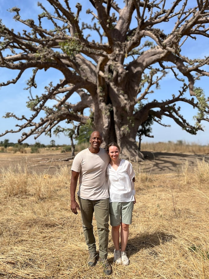 Couple in the African savannah, standing in front of baobab tree
